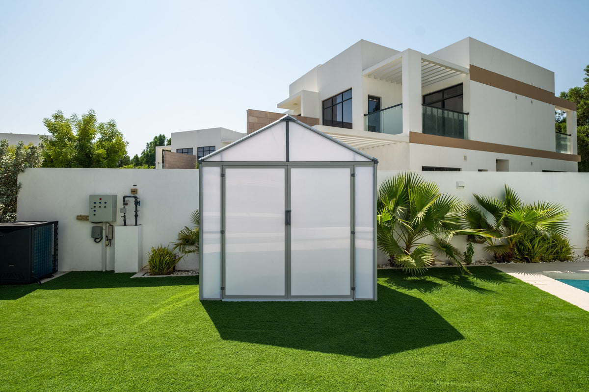 DOMER Smart Arctic Shed with grey profiles and closed double doors in a villa garden #Profile colour_Grey