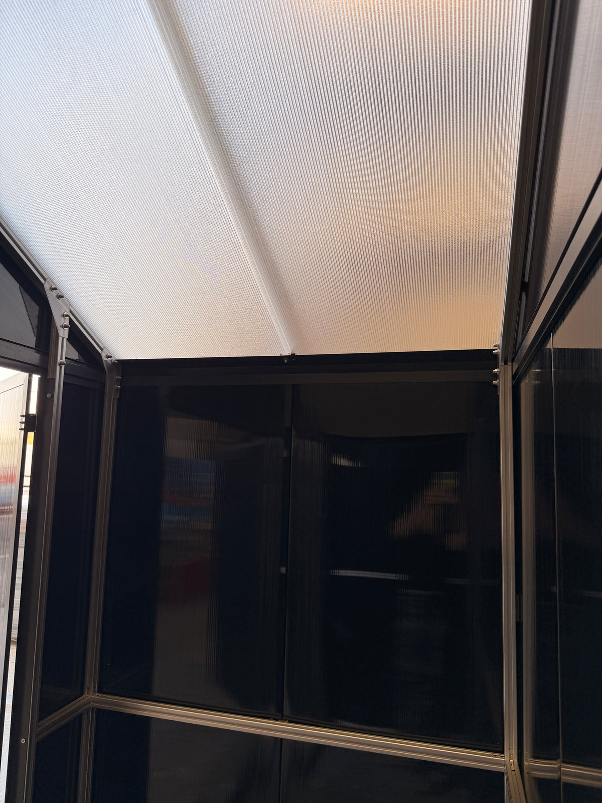 Inside the DOMER Smart Midnight Shed showing the translucent roof and black opaque walls