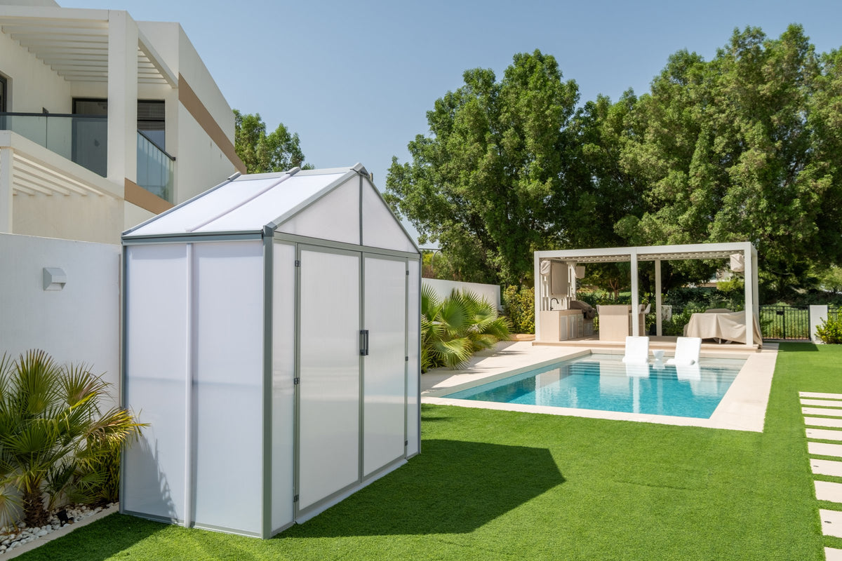 DOMER Smart Arctic Shed with grey profiles viewed from the side and front beside a swimming pool #Profile colour_Grey